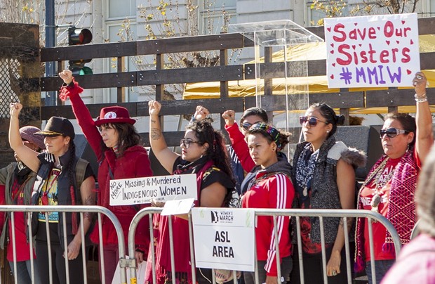 2018 Women's March San Francisco attendees raise fists and hold signs in support of missing and murdered indigenous women. - PHOTO BY PAX AHIMSA GETHEN VIA CREATIVE COMMONS (CC BY-SA 4.0)