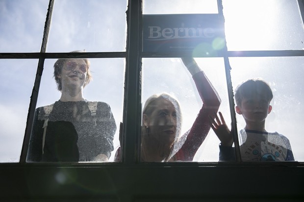 Supporters peer through the window during a Bernie Sanders presidential campaign event at Craneway Pavilion in Richmond, CA on February 17, 2020. - PHOTO BY ANNE WERNIKOFF FOR CALMATTERS