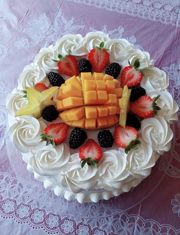 A mango-topped custom layer cake. - SUBMITTED