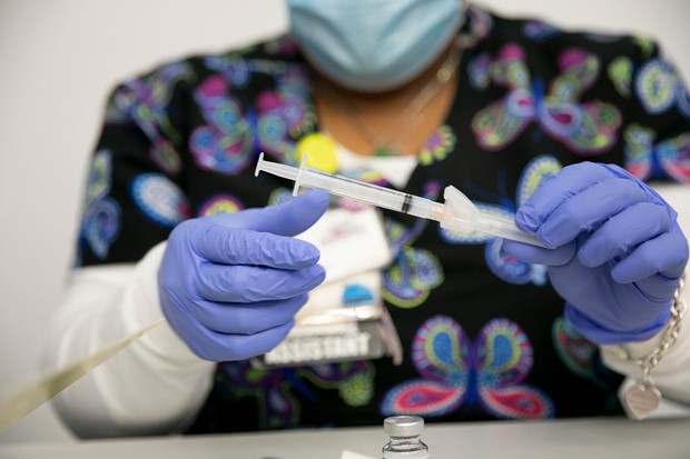 Medical assistant Letrice Smith fills syringes during a community COVID-19 vaccination clinic run by Ravenswood Family Health Network at Facebook headquarters in Menlo Park on April 10, 2021. - PHOTO BY ANNE WERNIKOFF, CALMATTERS