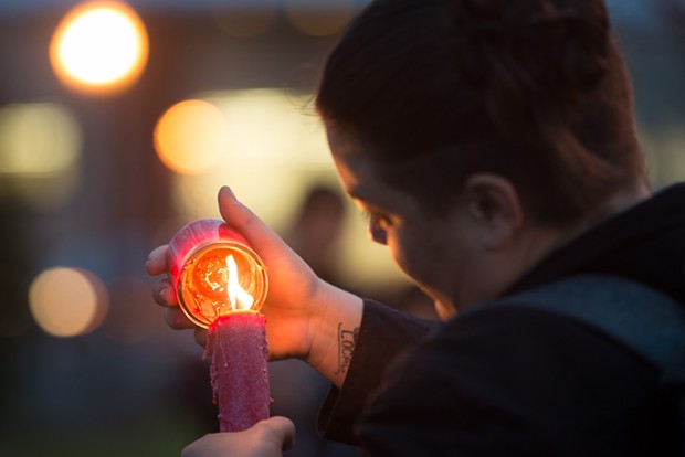 Molly Conso, pictured lighting a candle at a vigil for David Josiah Lawson, is suing the city of Eureka and county of Humboldt, alleging officers used excessive force during a protest of the 2020 murder of George Floyd. - MARK MCKENNA
