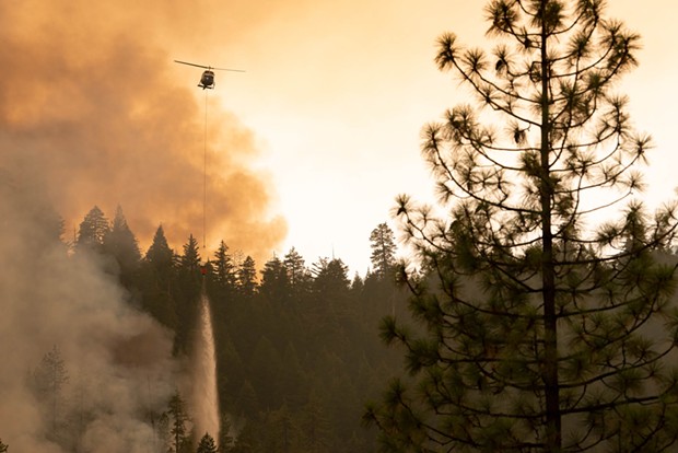 A helicopter drops water on the edge of the McFarland Fire. - MARK MCKENNA