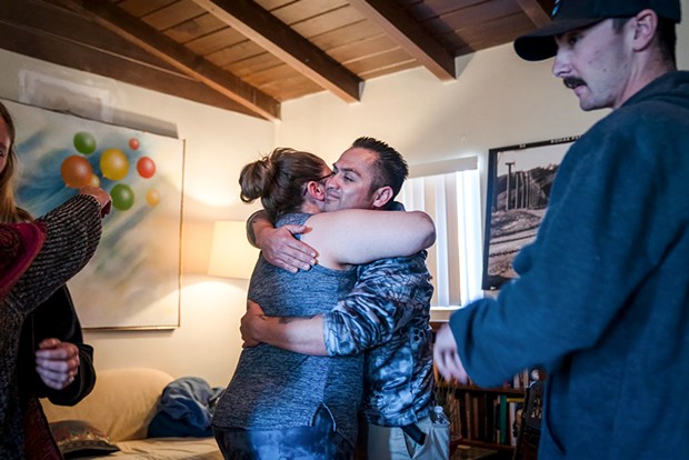 Cal Fire dispatcher Ali Wiseman and Capt. Hiram Vazquez embrace during a healing session at a trauma retreat in Desert Hot Springs. - PHOTO BY ARIANA DREHSLER FOR CALMATTERS