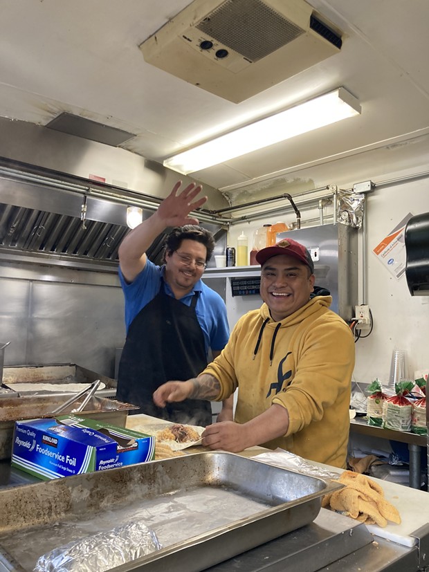 Enrique Buenrostro and David Velasco serve burritos to those without power and water in Rio Dell after the Dec. 20 quake. - PHOTO BY JENNIFER FUMIKO CAHILL