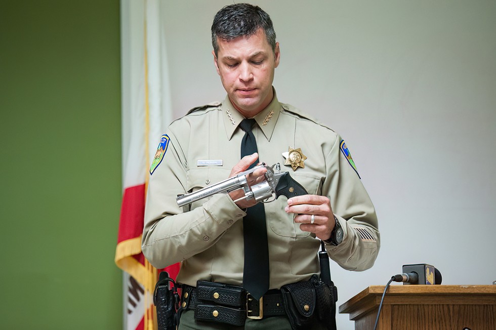 Humboldt County Sheriff William Honsal displays a pistol, brandished at deputies in a 2017 shooting, during a press conference. - HCSO