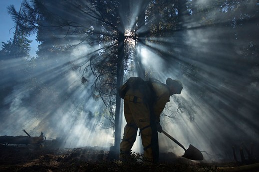 "Mopping up": Los Angeles County  structure firefighter Jeremy Jones puts dirt on a hotspot. - MARK THIESSEN, NATIONAL GEOGRAPHIC CREATIVE
