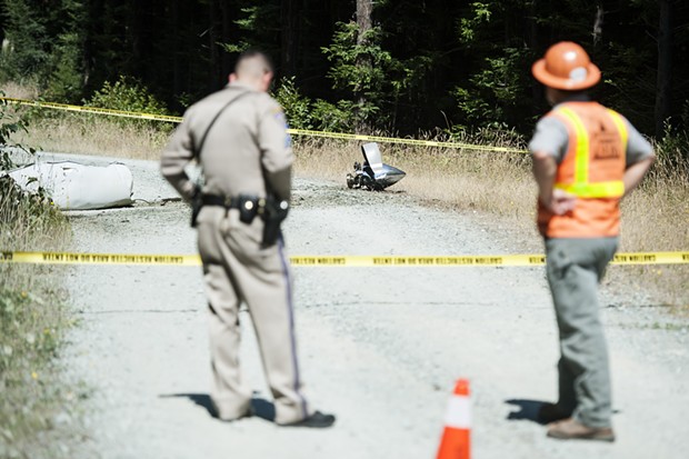 What appears to be part of a plane engine and propeller lie on an access road near the crash site. - MARK MCKENNA
