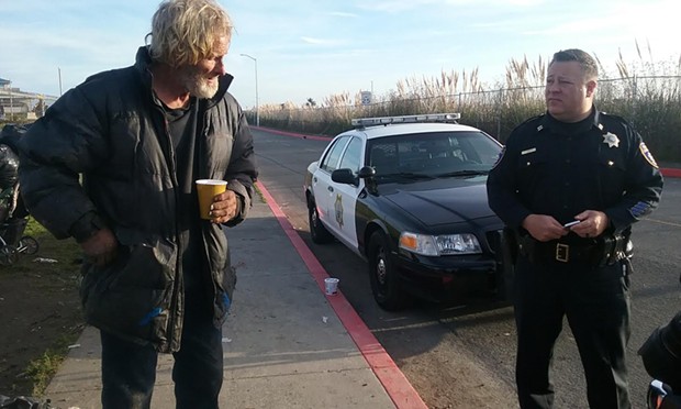 Captain Steve Watson talks to a homeless man vacating the sleeping area this morning. - LINDA STANSBERRY