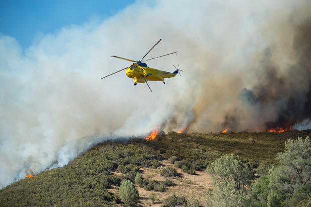 A Sikorsky helicopter prepares to refill its water hold to combat the Pawnee Fire earlier this week. - MARK MCKENNA