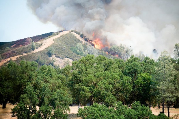 Fire breaks over a ridge at the Pawnee Fire last week. - MARK MCKENNA