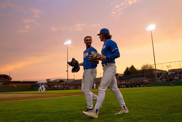 Outfielders Tyler Ganus (left) and Josh Lauck (right) head out to take the field as the sun begins to set over Arcata Ball Park on July 27.