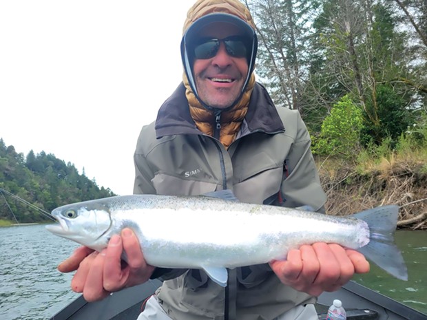 Scott Spangler of Bishop holds a small wild adult steelhead he caught March 21 on the Chetco River while fishing with guide Sam Stover of Brookings Fishing Charters.