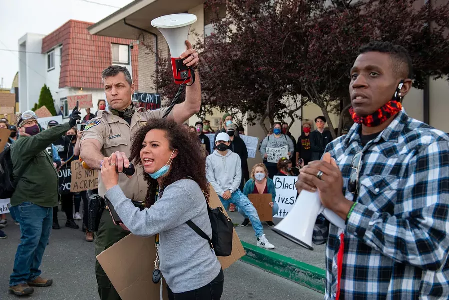 Humboldt County Sheriff William Honsal holds a microphone for protester Malia Haley as she addresses a crowd asking them to listen to what local law enforcement leaders had to say during a May 31 Black Lives Matter protest in Eureka. - MARK MCKENNA