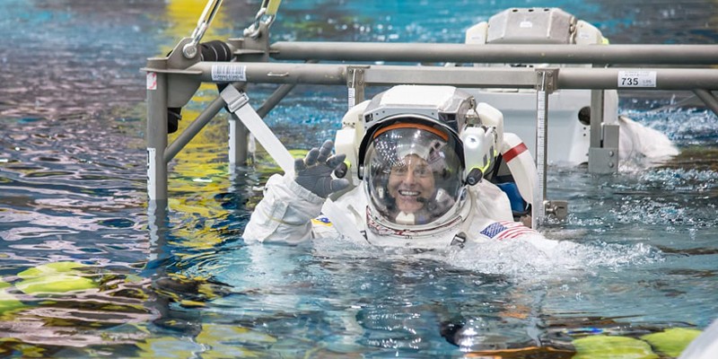 NASA astronaut Nicole Mann is lowered into the Neutral Buoyancy Laboratory during a spacewalk training session in 2014.