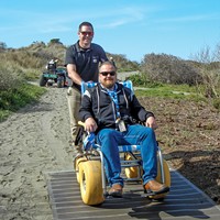 Travis Smith tests a plastic mat path designed to make Clam Beach accessible to the mobility-challenged.