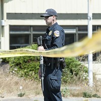 An officer guards the police line at the scene of a standoff in McKinleyville on Wednesday.