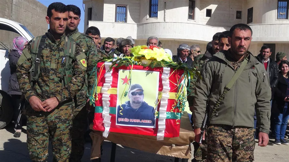 A screenshot from a YPG video of Paolo Todd's memorial service shows Kurdish soldiers carrying his casket through the streets of Rojava.