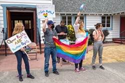 PHOTO BY MARK MCKENNA - Pride marchers stand in front of St. Mark's Lutheran Church Pastor Tyrel Bramwell as he reads scripture in 2021.