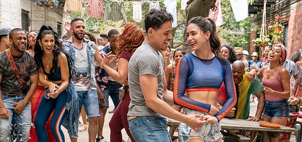 LA DANZA DE LA VIDA Usnavi (Anthony Ramos, left foreground) and Vanessa (Melissa Barrera, right foreground) take to the streets and dance with their neighbors, in the wildly entertaining and emotionally resonant musical, In the Heights, screening at most local theaters. - PHOTO COURTESY OF WARNER BROS.