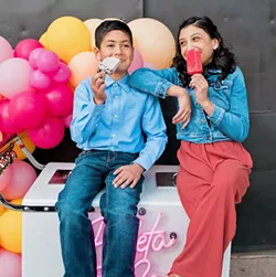 POPSICLE FUN (Left to right) Nolan Spears and Sophia Guzman enjoy a cold treat on top of the Paleta & Co. ice cream cart. - PHOTO COURTESY OF STEFANIE ELIZABETH PHOTOGRAPHY