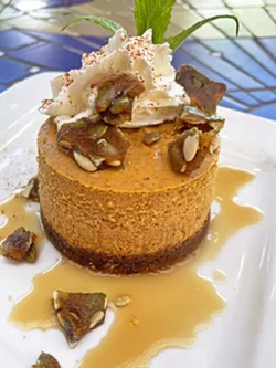 PUMPKIN PERFECTION Cinnamon whipped cream and brown butter caramel sauce complement Robin's Restaurant's seasonal pumpkin cheesecake. The pièce de résistance is its pepita brittle garnish (see recipe, below). - PHOTO COURTESY OF ROBIN'S RESTAURANT