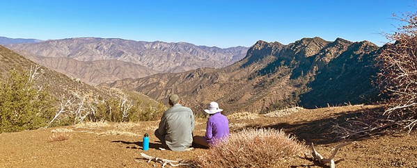 ENJOY THE VIEWS Two volunteers with the Los Padres Forest Association take a break to enjoy views of the rugged mountains. - PHOTO COURTESY OF LOS PADRES FOREST ASSOCIATION