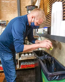 COMPOSTING FOOD Big Sky Restaurant owner Greg Holt separates his food waste into a green bin, something that almost all of the restaurants in the county will be required to do as part of new rules that went into effect at the beginning of the year. - PHOTO BY JAYSON MELLOM