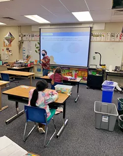 LEAKY CEILINGS A Georgia Brown Elementary School teacher conducts class while trash cans collect water from the leaking roof. - PHOTO COURTESY OF COURTNEY PERALES