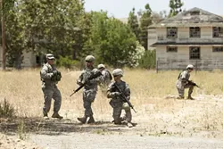 SIMULATED SITUATION : A group of recruits practices methods for securing an improvised explosive device. By repeatedly drilling life-like scenarios, soldiers learn to react quickly and decisively to the real thing. - PHOTO BY STEVE E. MILLER