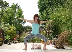 BALANCING ACT: Local yoga instructor and m.Body co-founder Tawny Sterios finds her center. With a rollup door that reveals lush plant life and blue skies, the SLO-based studio is breezy and refreshing. - PHOTO BY HAYLEY THOMAS