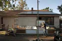 ‘A WORK IN PROGRESS’ : Jim Eickholdt at the Paso Robles home he shares with his wife and daughter. The family must now deal with alleged building code violations after NTF officers called the county building department following a search of the home. - PHOTO BY STEVE E. MILLER