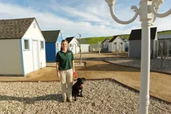 FRIENDS : Weekend manager Kristen Nelson shares a quiet moment with frequent guest Summer, a frisky nine-month-old Labrador retriever who’s somewhat nervous about photographers. - PHOTO BY STEVE E. MILLER