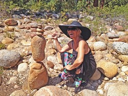 TOWERING FIGURE:  Kathy Clarke (right) has been stacking rocks most of her life, as a hobby and as a way to enhance the outdoor experience. - PHOTO COURTESY OF KATHY CLARKE