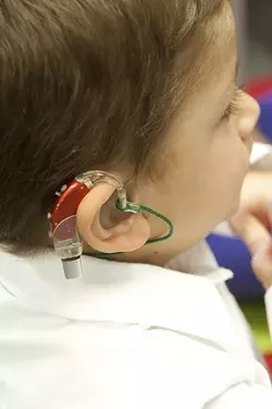 AMPLIFYING AID: Preschooler Thomas’s colorful hearing aid turns on a world of sound. - PHOTO BY STEVE E. MILLER