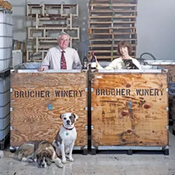 TEAM EFFORT : Mike and Janis Schmidt own and operate the Brucher and Golden Bear wine company in Santa Maria, which help from Gracie (lying down), Pirate, and Dub (in Janis’ arms). - PHOTO BY STEVE E. MILLER