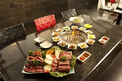 MARBLED PERFECTION : Definitely more food than one person can handle, this spread at SizzlinGogi is just a sampling of what’s available on the menu, which is all cooked on the grill in the middle of the table. - PHOTOS BY STEVE E. MILLER