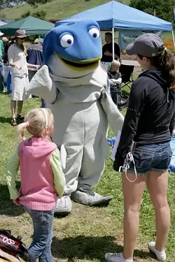 WATCH WHAT YOU PUT DOWN STORM DRAINS, KIDS! : Sammy the Steelhead Trout greets Earth Day attendees! - PHOTO BY GLEN STARKEY