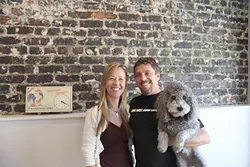 IN THE DOGHOUSE: Liz and Brian Espy, with Mop the dog, are owners of Doghouse Promotions, a small company specializing in promotional branding that recently relocated to downtown SLO. - PHOTO BY REBECCA LUCAS