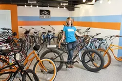 ELECTRIFYING RIDES: One can buy or rent various models of Pedego electric bicycles in Avila Beach. Sandra Napua, director of marketing, stands behind the Trail Tracker model that can even be ridden on sand. - PHOTO BY STEVE E. MILLER