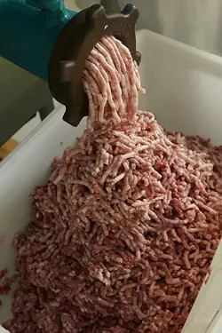 7: : Ground meat and pork belly comes out of the grinder.
