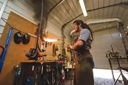 FLAME ON: Randolph uses an oxygen acetylene torch to weld two pieces of steel together. - PHOTO BY KAORI FUNAHASHI
