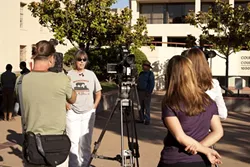 MAD AS HELL : Becky Jorgeson, an advocate for the homeless, fielded questions from media and a Los Angeles-based documentary film crew in front of the San Luis Obispo County Superior Courthouse on Sept. 7 while protesting an alleged lack of services for the local homeless population. - PHOTO BY STEVE E. MILLER