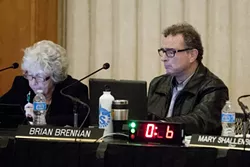 STEWARDS OF THE COAST : Ventura City Councilman Brian Brennan, representative for the coastal commission’s South Central Coast region—which includes San Luis Obispo and Santa Barbara counties—reads up on a staff report during an application hearing for the City of Pismo Beach’s controversial sea wall project. Commissioner Jana Zimmer sits left. - PHOTO BY STEVE. E. MILLER