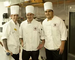 CHEFS O’PLENTY : Chefs Andrew Kossuth, Jimmy Ramirez, and Efren Alvarez work in a huge kitchen behind the fresh food cabinet.