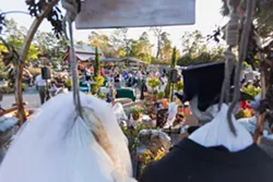 GRIM GREETERS: Two skeleton scarecrows tower above the Scarecrow Festival’s kick-off party, held at Cambria Nursery & Florist, where the judges’ selections for best scarecrows are announced. - PHOTO BY KAORI FUNAHASHI