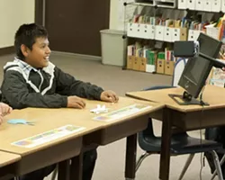 VISION QUEST: A 12-year-old deaf student uses an up-close reader to help him see his teacher’s signing hands. - PHOTO BY STEVE E. MILLER