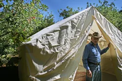 CAMP OUT : SLO-based glamping outfitter Whereabout has partnered with FARMstead ED and Windrose Farms to present bohemian-style camping during the farm’s annual Heirloom Tomato Fest slated for Sept 20-21 in Paso Robles. Pictured, Windrose Farm owner Bill Spencer checks out the canvas tent in the days leading up to the celebration of all things big, red, and juicy. - PHOTO BY HAYLEY THOMAS