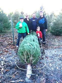 GO BIG OR GO HOME: The Wood boys—Andrew, Evan, and Logan (from left to right)—and Merissa and Tim James (center), picked a 10-foot tall Monterey Pine that the kids were convinced was the perfect fit. Good thing they have vaulted ceilings at home. - PHOTO BY JONO KINKADE