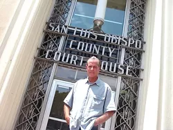 Lawrence Bass stands outside the SLO County courthouse, where he has filed restraining orders against a sheriff’s deputy and a judge. - PHOTO BY COLIN RIGLEY
