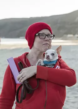 LIFE AQUATIC, AND CANINE: Newlywed Aileen Manley, wearing the red beanie that has become the trademark of this ridiculous event, protected her love Taco from the elements. - PHOTO BY COLIN RIGLEY